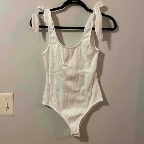 Tops - Brand new white bodysuit with adjustable tie straps over shoulder.